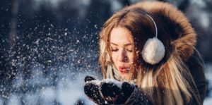 young woman playing with snow